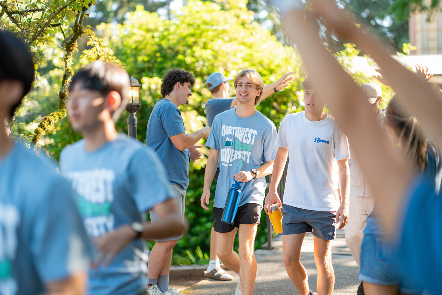 Students wearing Northwest University t-shirts walk across campus during Welcome Weekend.