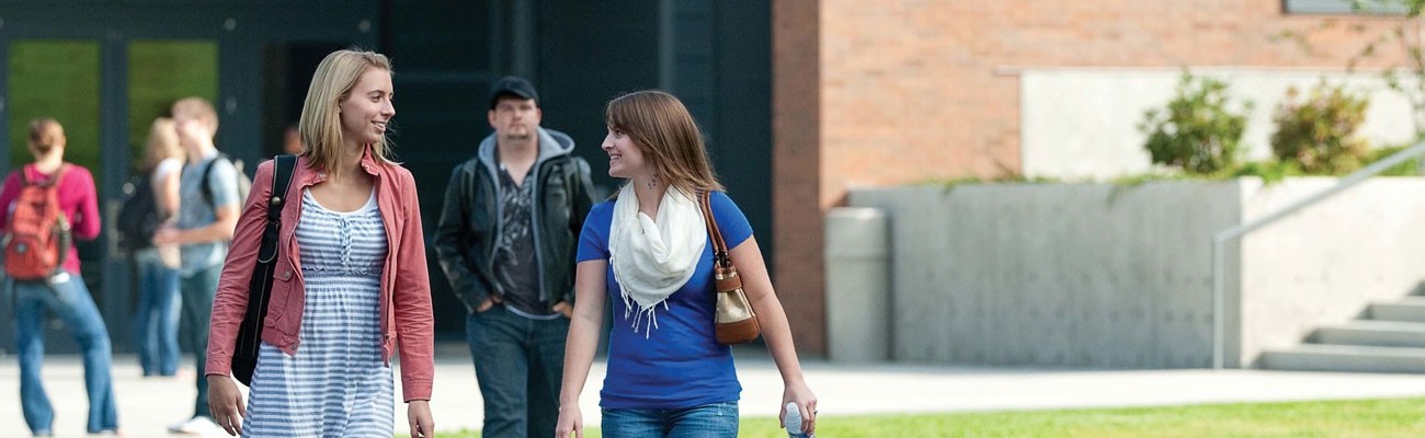 Students talking while walking across campus.